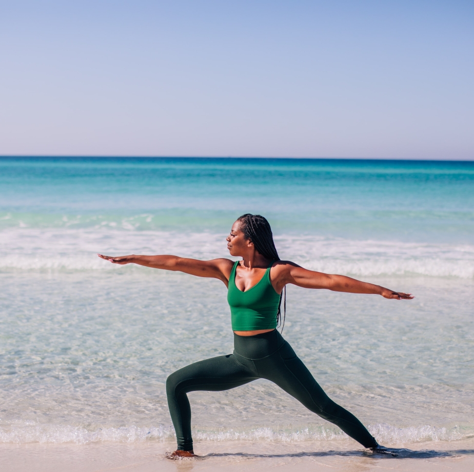 woman doing yoga pose on beach