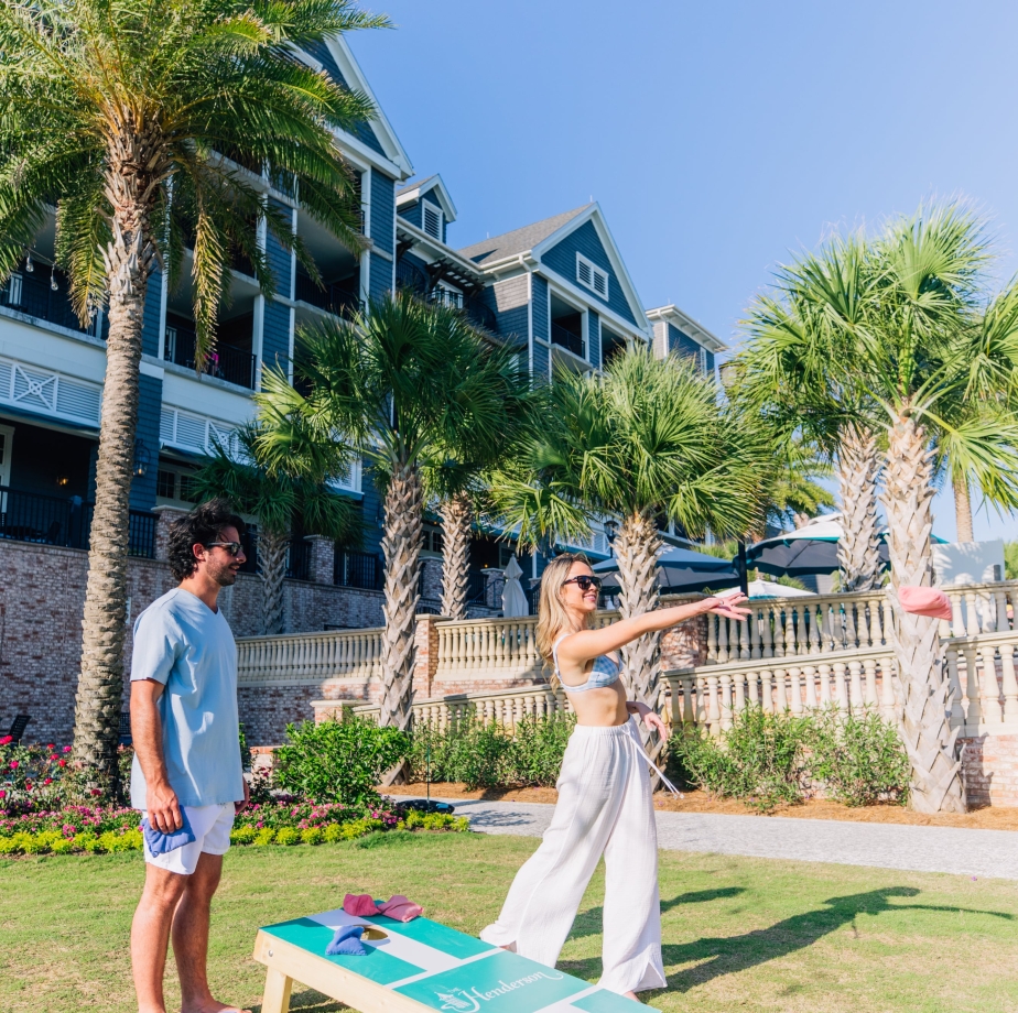 couple playing cornhole on resort lawn